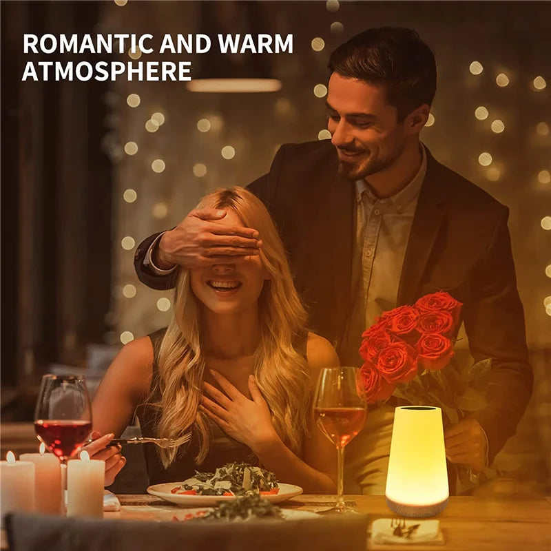 Romantic dinner scene with a couple, a bouquet of red roses, and a color-changing table lamp creating a warm atmosphere.